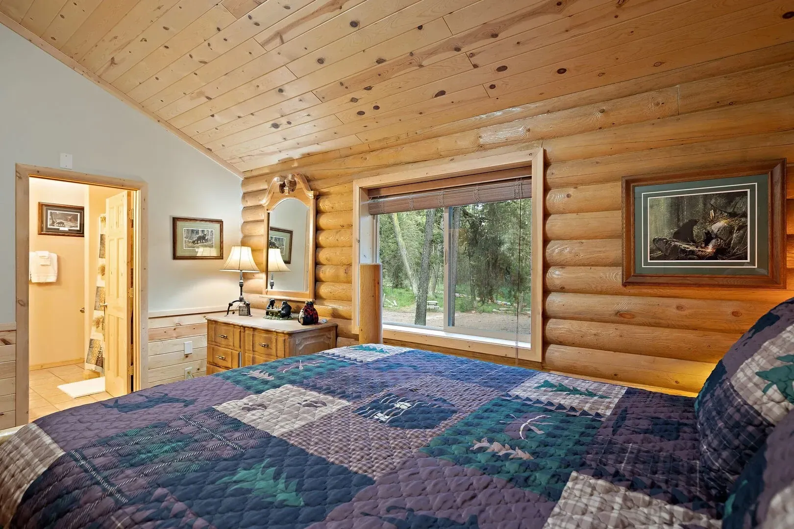 Bear-themed master bedroom with a cozy log bed, mirror, and drawers