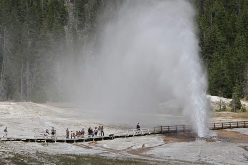 Visitors watching Beehive Geyser erupt along the Upper Geyser Basin boardwalk
